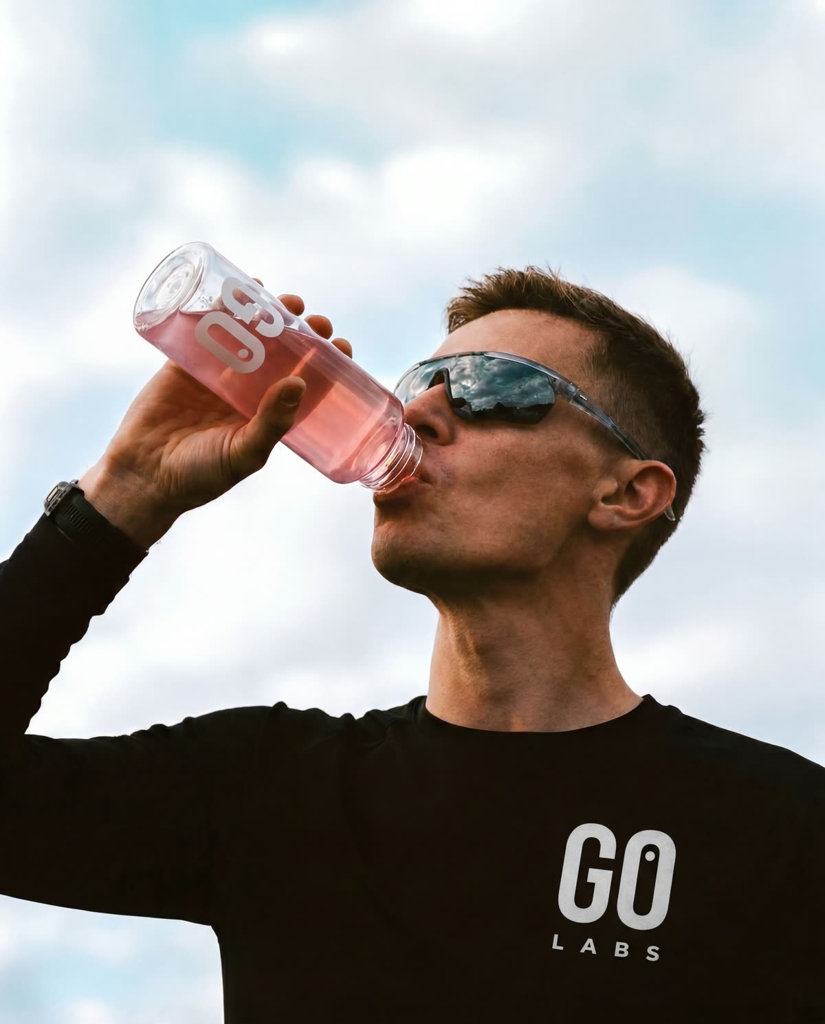 A man drinking pink GO, under the sky