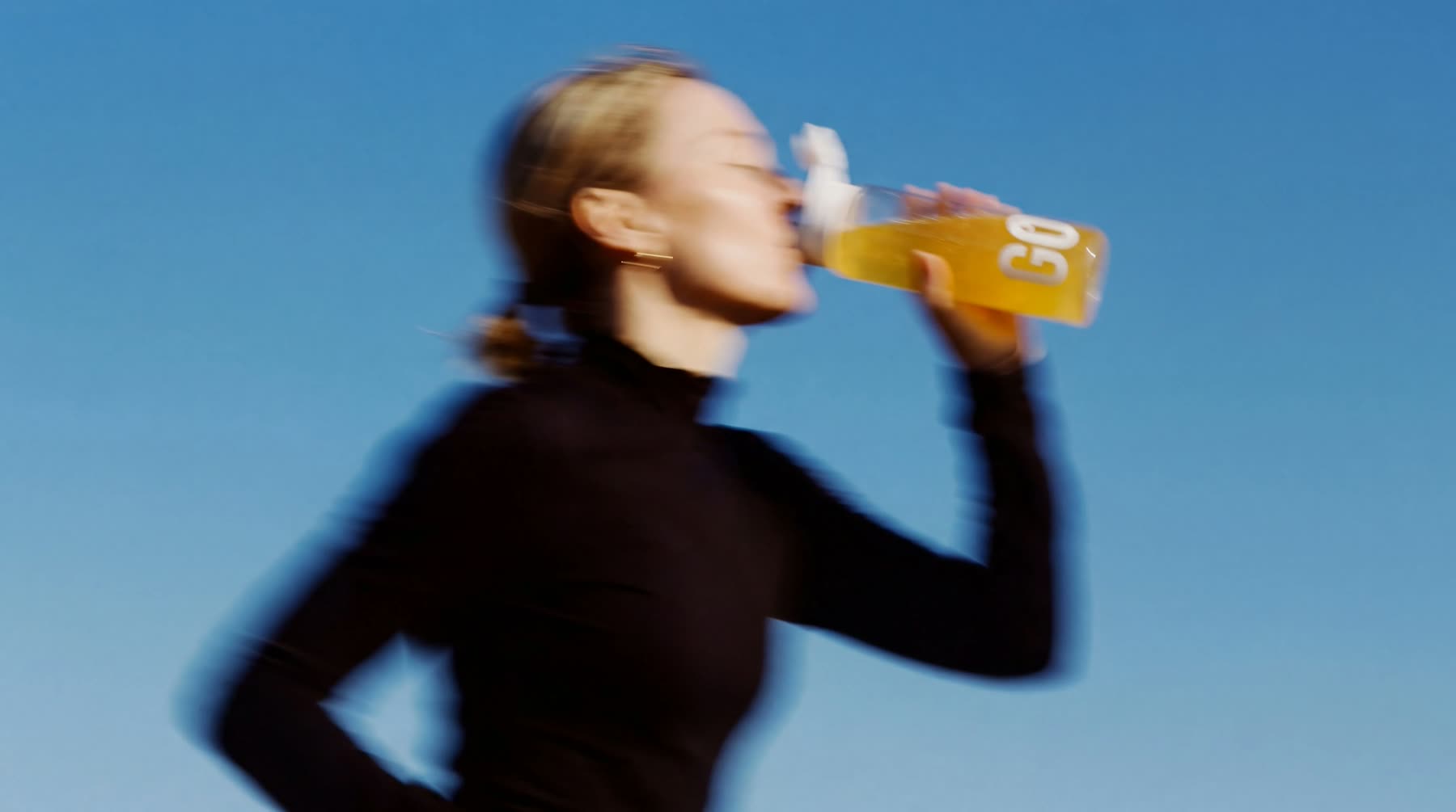 A runner drinking GO, in motion